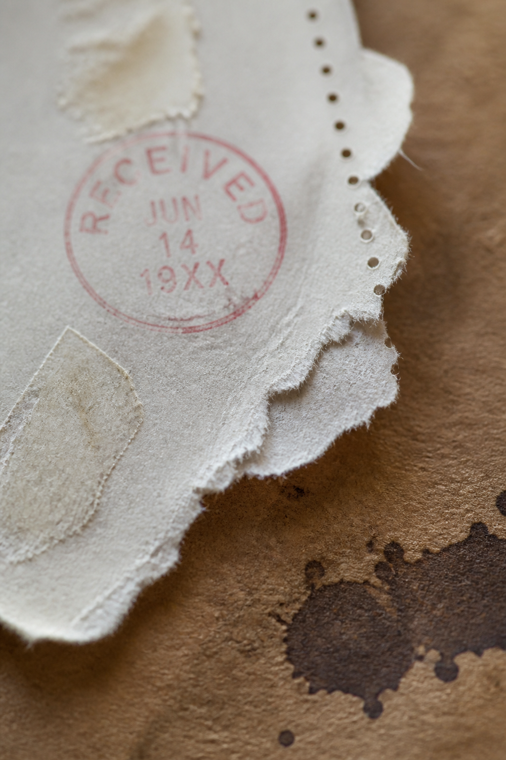 Torn receipt edge with perforation dots and a small circular ink mark